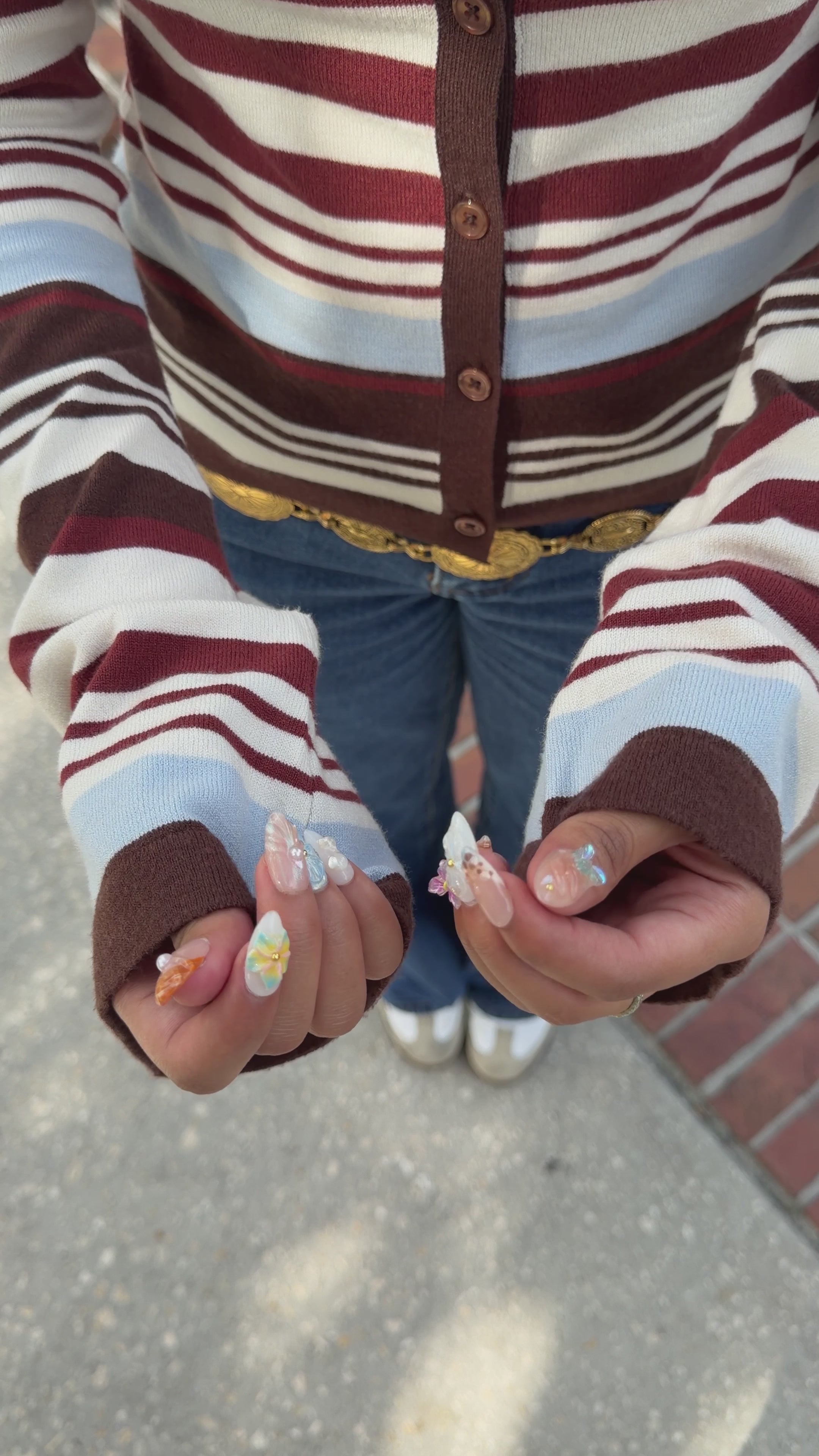 Load video: A model showing off her look and fresh nail set.